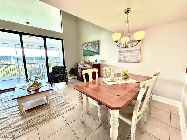 a view of a dining room and livingroom with furniture wooden floor a chandelier