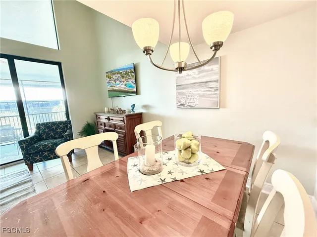 a view of a dining room with furniture a chandelier and wooden floor