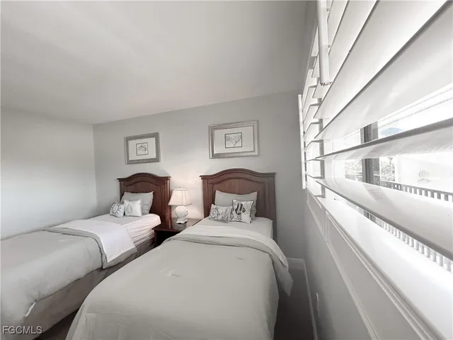 a bedroom with two beds and a large window