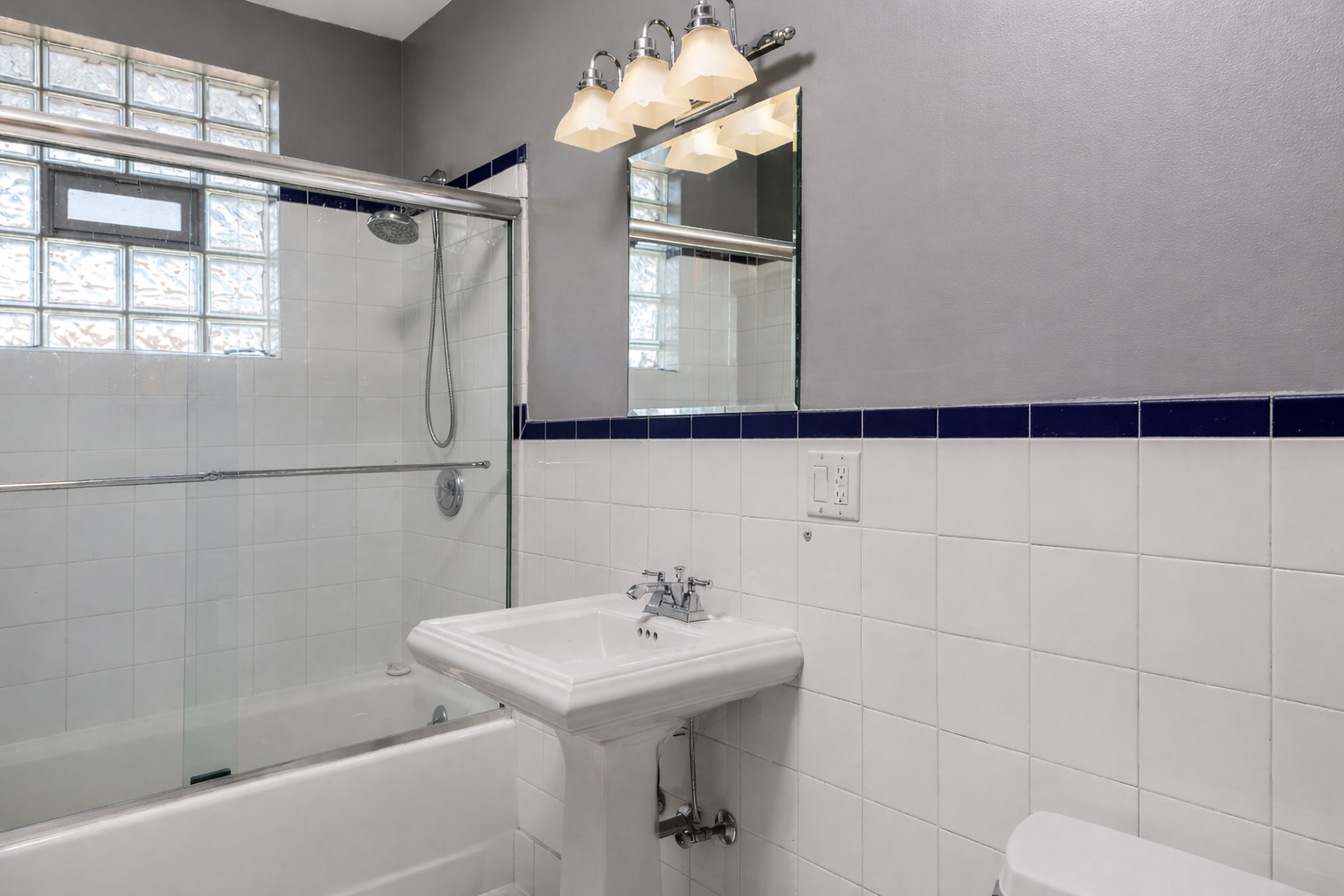 1901 West Fletcher Street, Unit 2 Chicago, IL 60657 - Photo 5 of 10 a bathroom with a sink a mirror and a shower