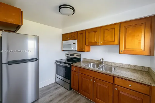 a kitchen with a refrigerator sink and cabinets