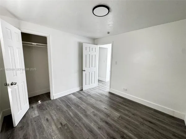 an empty room with wooden floor and closet