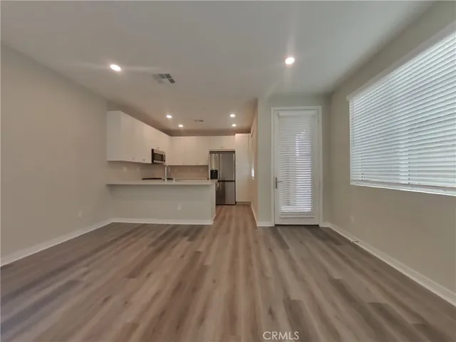 a view of large kitchen with wooden floor and windows