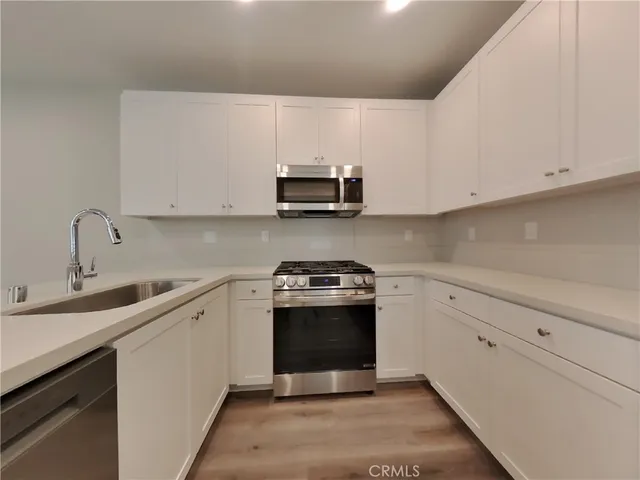 a kitchen with stainless steel appliances granite countertop a sink and a stove