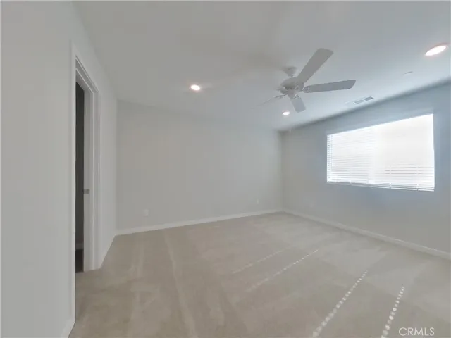 an empty room with a window and a fan