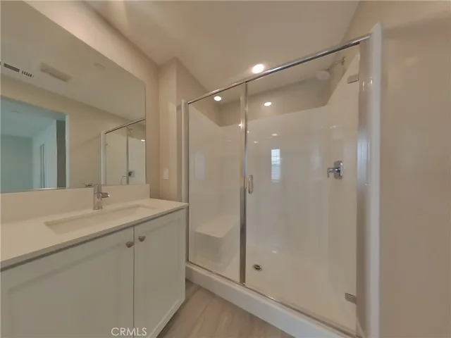 a bathroom with a shower sink vanity and mirror