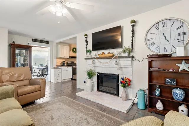 a living room with furniture a flat screen tv and a fireplace