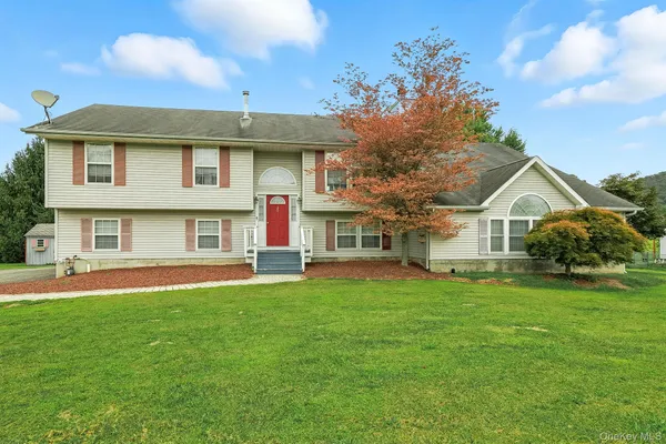 a front view of a house with a garden and yard