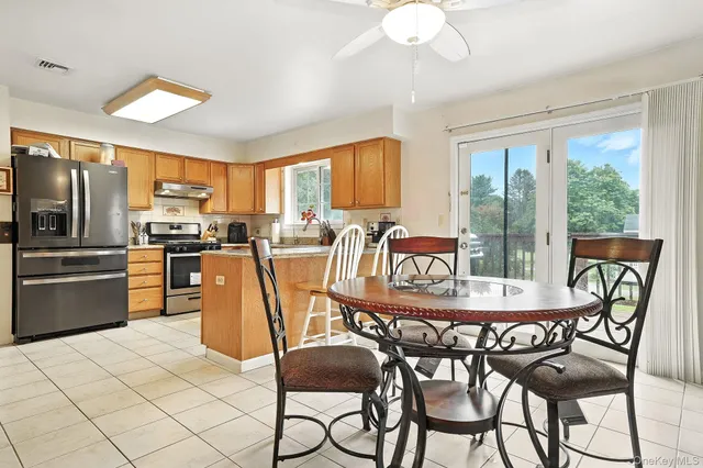 a dining table with chairs and kitchen view
