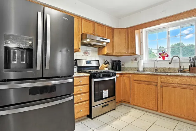 a kitchen with stainless steel appliances granite countertop a refrigerator sink and stove