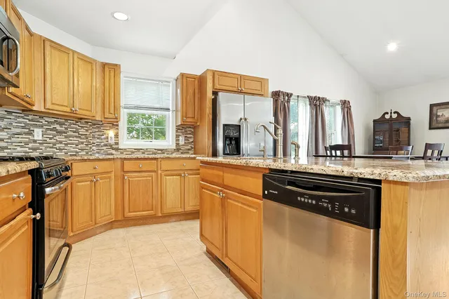 a kitchen with stainless steel appliances granite countertop a stove a sink and a refrigerator