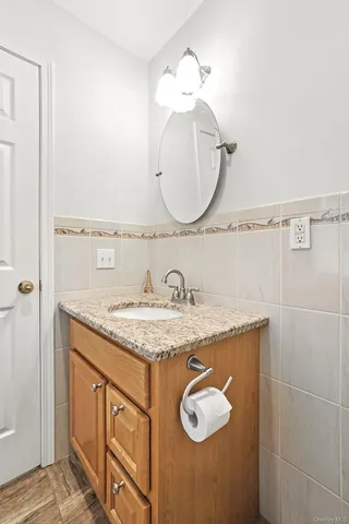 a bathroom with a granite countertop sink a mirror and shower