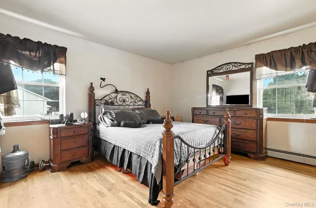 a bedroom with furniture a flat screen tv and a window