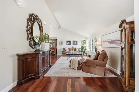 a living room with furniture a fireplace and wooden floor