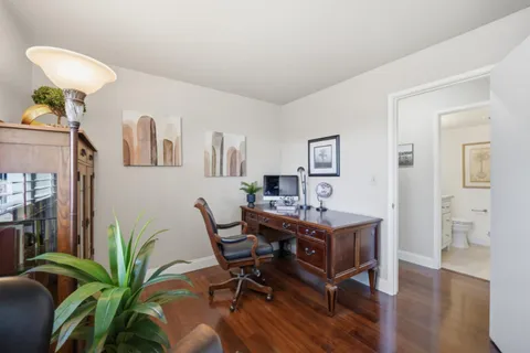 a view of a workspace with furniture and wooden floor
