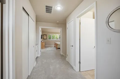 a view of a hallway with wooden floor and a livingroom view
