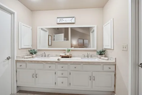 a bathroom with a double vanity sink and mirror