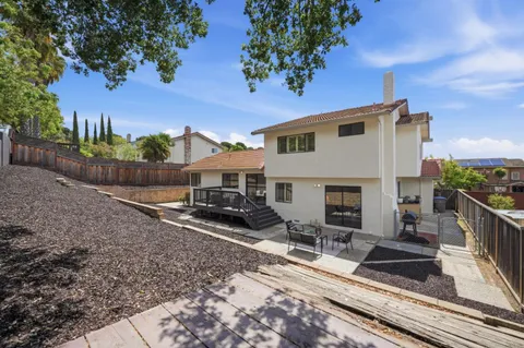 a view of a house with backyard and sitting area
