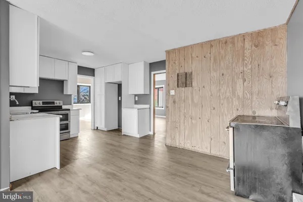 a kitchen with stainless steel appliances wooden floor and a refrigerator