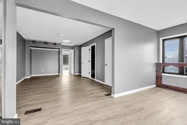 a view of a livingroom with wooden floor and furniture