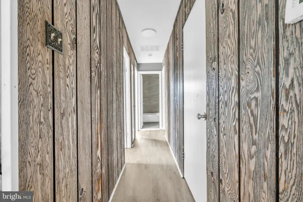 a view of a hallway with wooden floor and glass door