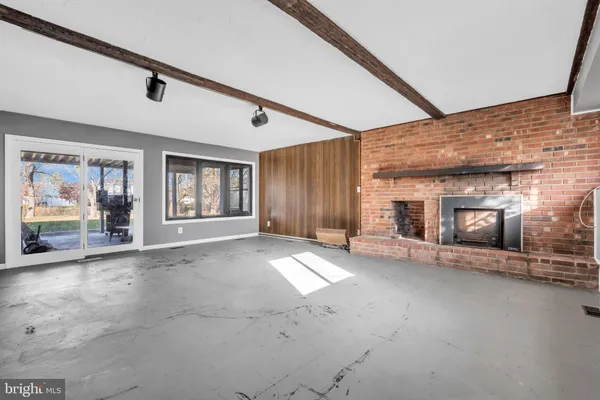 a view of a livingroom with fireplace and window