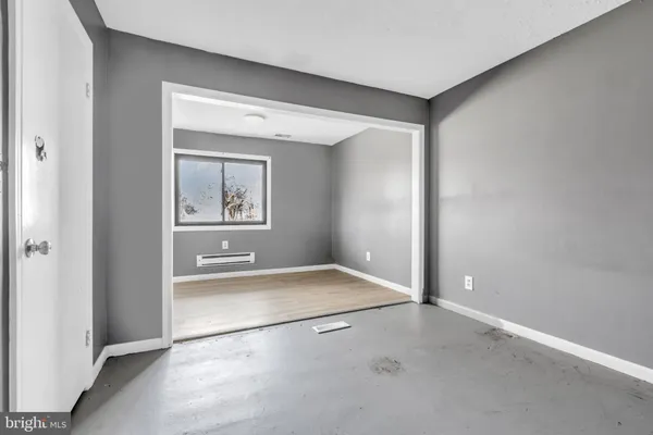 an empty room with windows and mirror