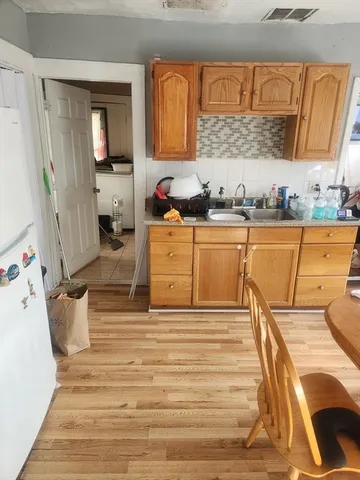 a view of a kitchen with wooden floor and cabinets