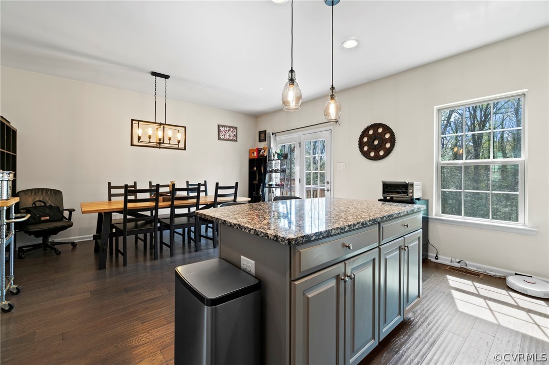 5505 Riverside Heights Way Richmond, VA 23225 - Photo 5 of 30 a kitchen with stainless steel appliances granite countertop a stove oven a dining table and chairs with wooden floor
