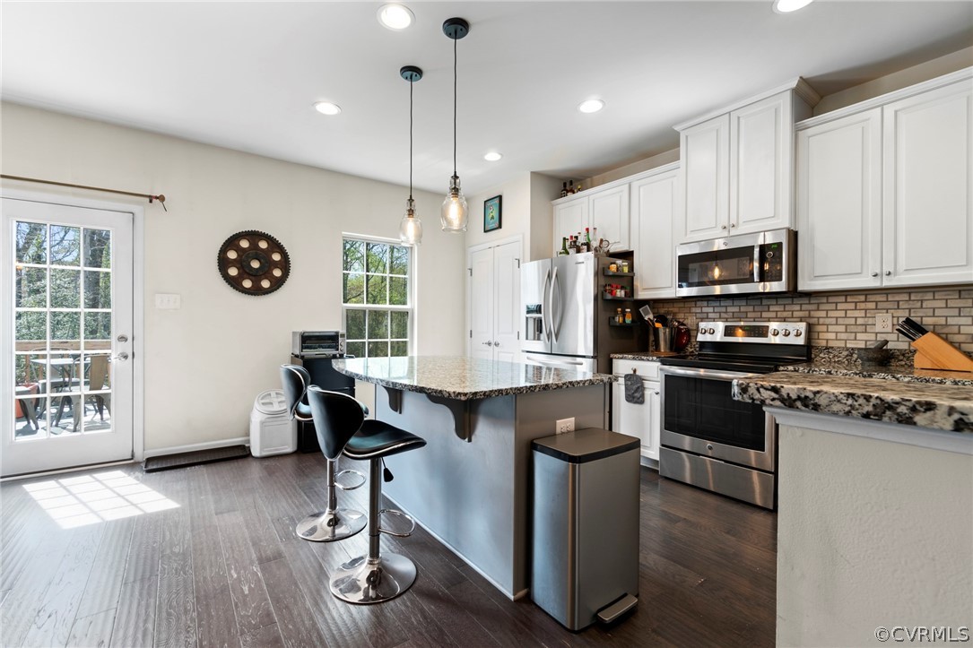 5505 Riverside Heights Way Richmond, VA 23225 - Photo 6 of 30 a kitchen with stainless steel appliances granite countertop a stove a refrigerator a sink dishwasher a oven with white cabinets and wooden floor