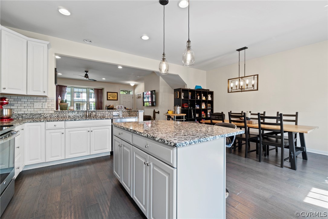5505 Riverside Heights Way Richmond, VA 23225 - Photo 7 of 30 a kitchen with stainless steel appliances granite countertop a kitchen island a stove a table and chairs