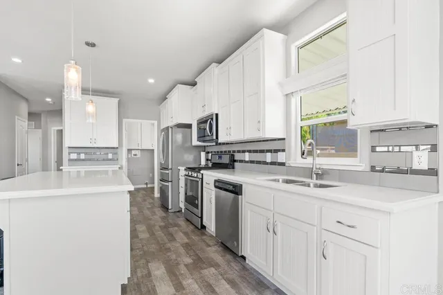 a kitchen with white cabinets sink and stainless steel appliances