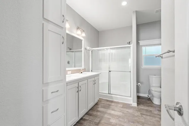 a bathroom with a double vanity sink toilet and shower