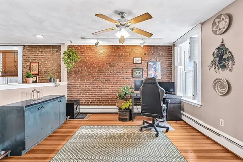 a view of a livingroom with workspace and a window