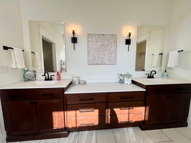 a large bathroom with a double vanity sink a large mirror and a shower