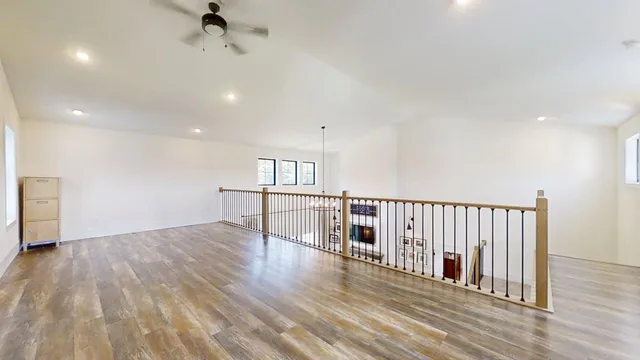 a dining room with wooden floor a chandelier a glass table and chairs