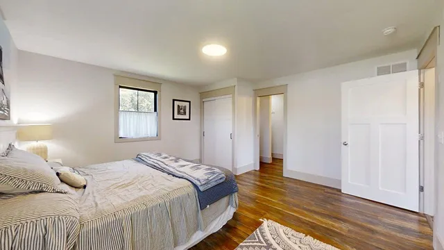 a bedroom with a bed and wooden floor