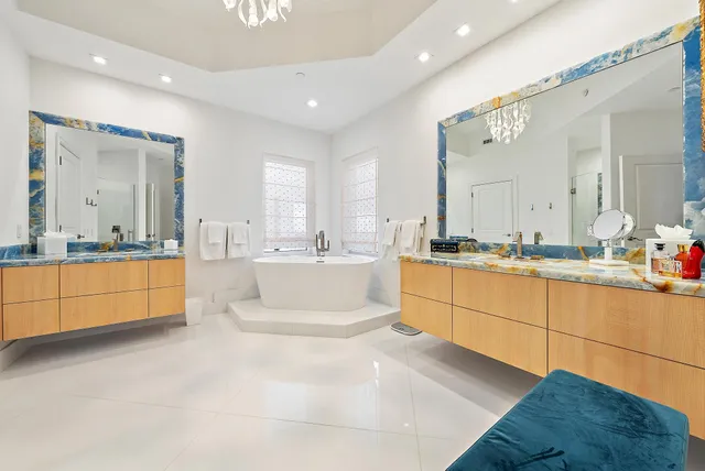 a large bathroom with a large tub sink vanity and mirror