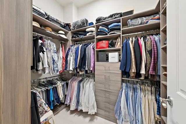 a view of walk in closet with clothes