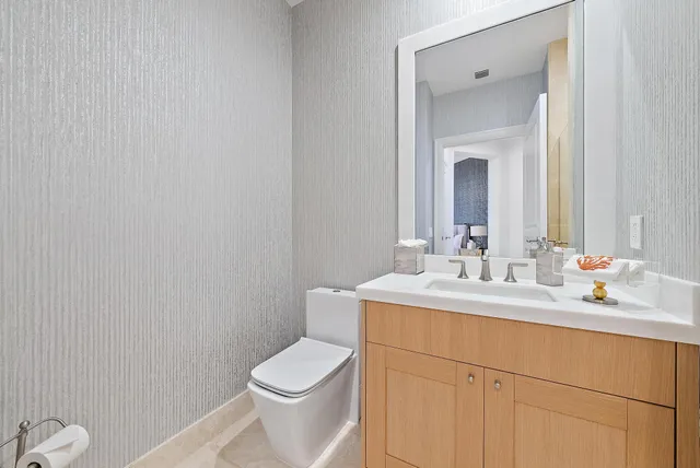 a bathroom with a toilet sink vanity and mirror