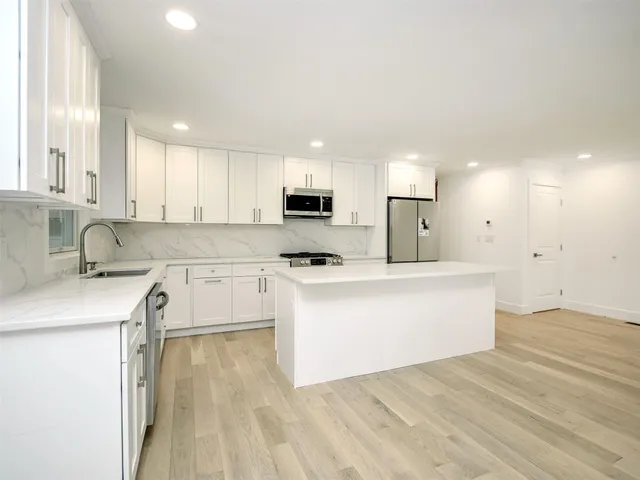 a kitchen with a refrigerator a sink and cabinets
