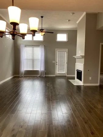 a view of a living room with wooden floor and cabinet