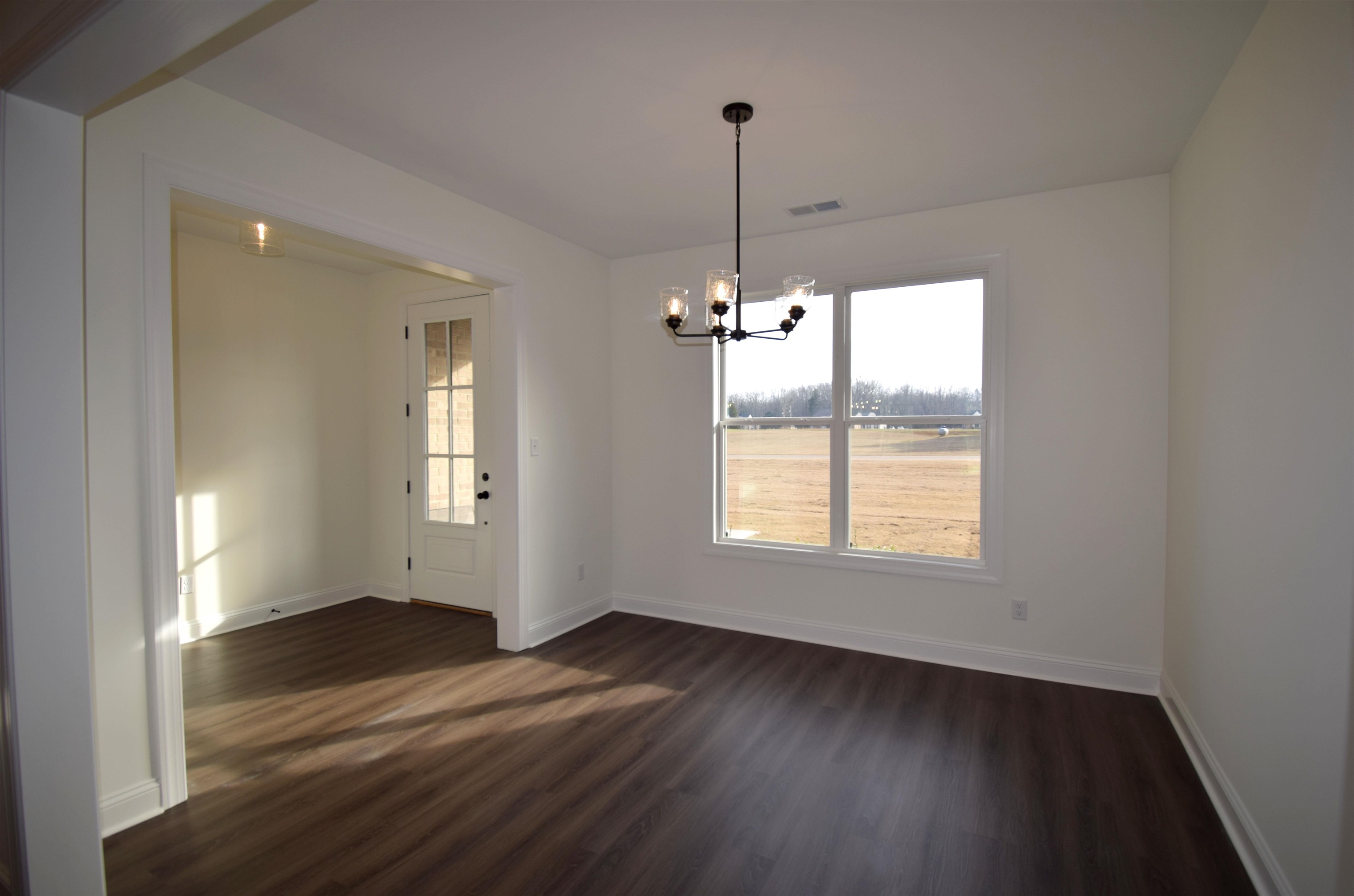 207 Centerline Roper Loop Byhalia, MS 38611 - Photo 3 of 23 a view of an empty room with wooden floor fridge and a window