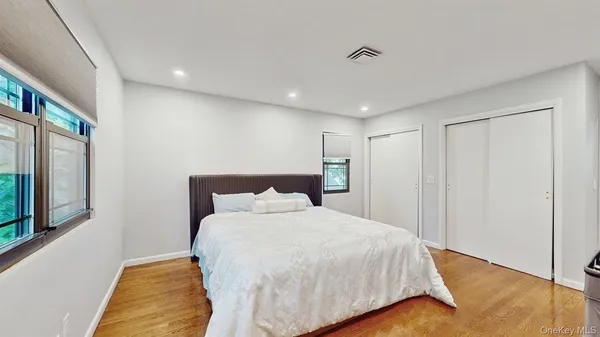 a bedroom with a large bed and a painting on the wall