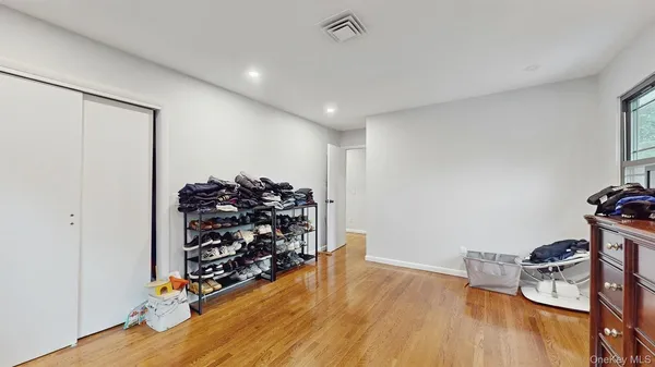 a view of a room with wooden floor closet and a window