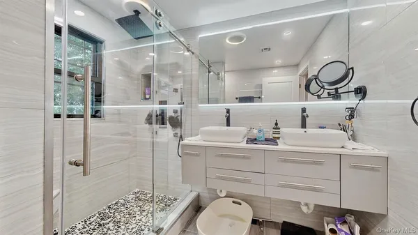 a bathroom with a sink a toilet and shower