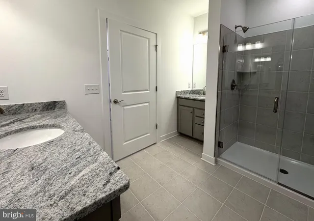 a bathroom with a granite countertop sink a toilet and shower