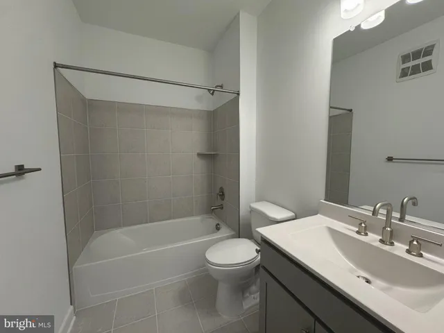 a bathroom with a bathtub shower sink vanity and toilet