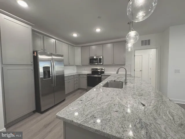 a large kitchen with kitchen island a sink stainless steel appliances and cabinets
