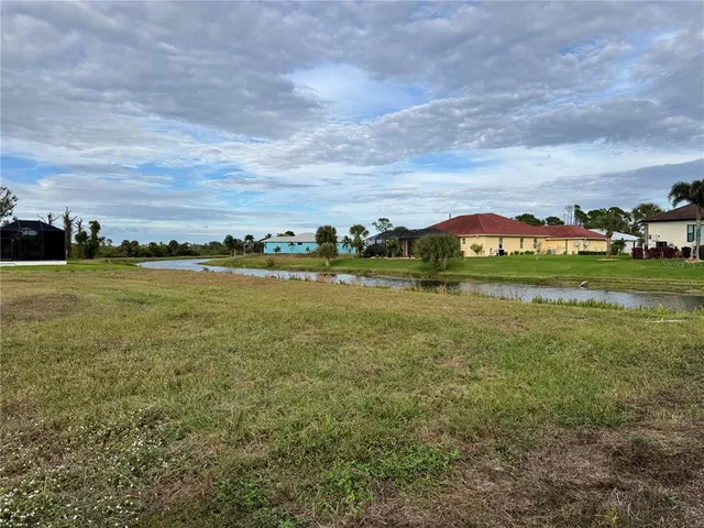 a view of a lake with a big yard and large trees